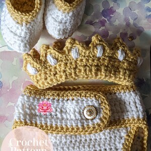 May include: Crochet pattern PDF file for a baby outfit. The outfit includes a crown, diaper cover, and booties. The crown and diaper cover are yellow and white, and the booties are white with yellow trim.