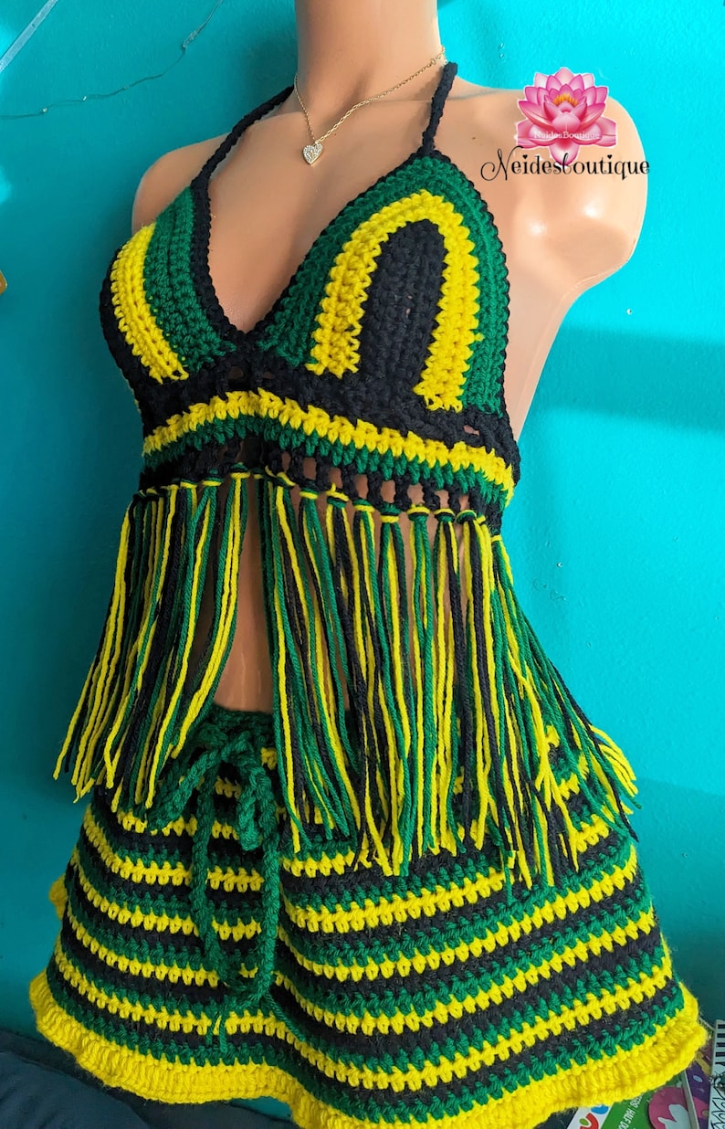 Pu&ograve; includere: Un set di bikini in crochet composto da top e gonna a righe verdi, nere e gialle. Il top ha frange e la gonna ha una chiusura a laccio.
