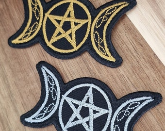 May include: Two embroidered patches featuring the triple moon symbol and a pentagram. One patch is gold on black fabric, and the other is silver on black fabric.