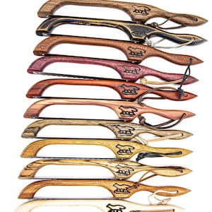 May include: A set of ten hand-crafted wooden folding saws with a unique design. Each saw features a different wood type and a wolf logo. The saws are all in a row, with the handles facing up.