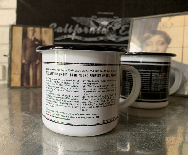 Peut inclure: Une tasse en &eacute;mail blanc avec un bord et une poign&eacute;e noirs. La tasse pr&eacute;sente une impression noir et blanc du texte "D&eacute;claration des droits des peuples noirs du monde". Le texte comprend les mots "Nous croyons en la libert&eacute; du monde pour le peuple noir" et "Nous exigeons le contr&ocirc;le total de toutes les institutions sociales sans ing&eacute;rence de la part de aucune race."