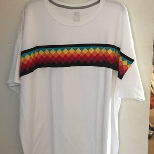 May include: White t-shirt with a black, red, orange, yellow, and blue geometric pattern across the chest.