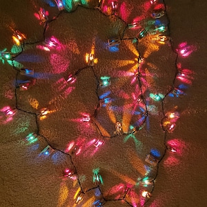 May include: A string of colorful fairy lights with clothespins, creating a whimsical and festive atmosphere.