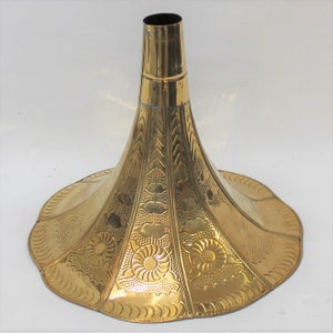 Puede incluir: Un cuerno de gram&oacute;fono de metal dorado con un dise&ntilde;o ornamentado. El cuerno se ensancha en la parte inferior y tiene una abertura estrecha en la parte superior.