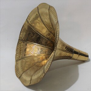 Puede incluir: Un cuerno de gram&oacute;fono de lat&oacute;n dorado con un dise&ntilde;o floral ornamentado. El cuerno se ensancha en la abertura y tiene un cuello estrecho.
