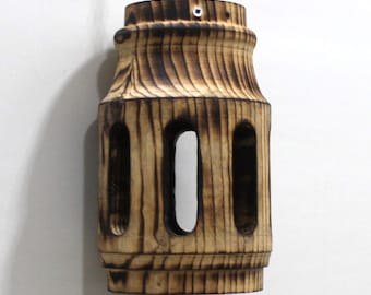 May include: A wooden hanging lamp with a cylindrical shape and a burnt wood finish. The lamp has three rectangular openings on each side.