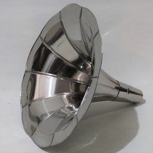 Puede incluir: Un cuerno de gram&oacute;fono de metal plateado con una campana acampanada y estriada y un cuello largo y recto.