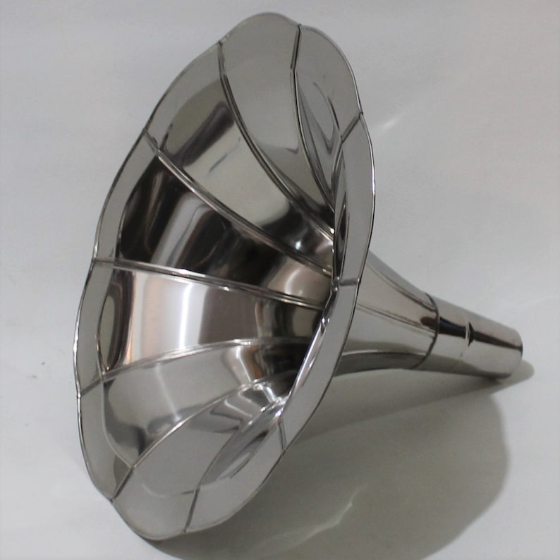 Puede incluir: Un cuerno de gram&oacute;fono de metal plateado con una campana acampanada y estriada y un cuello largo y recto.