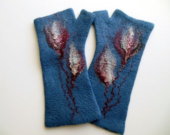 Può includere: Un paio di guanti senza dita in lana infeltrita blu. Ogni guanto presenta un motivo decorativo composto da tre forme floreali astratte nei toni del bordeaux, bianco e grigio scuro, con sottili linee ondulate che scendono dai fiori.