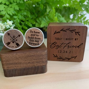 May include: A wooden box with a lid engraved with the text "Today I marry my Best Friend 12.24.21". The box contains two wooden cufflinks with silver accents. One cufflink is engraved with the text "To have and to hold from this day forward". The other cufflink is engraved with the text "S B R 10.24.20" and two arrows.
