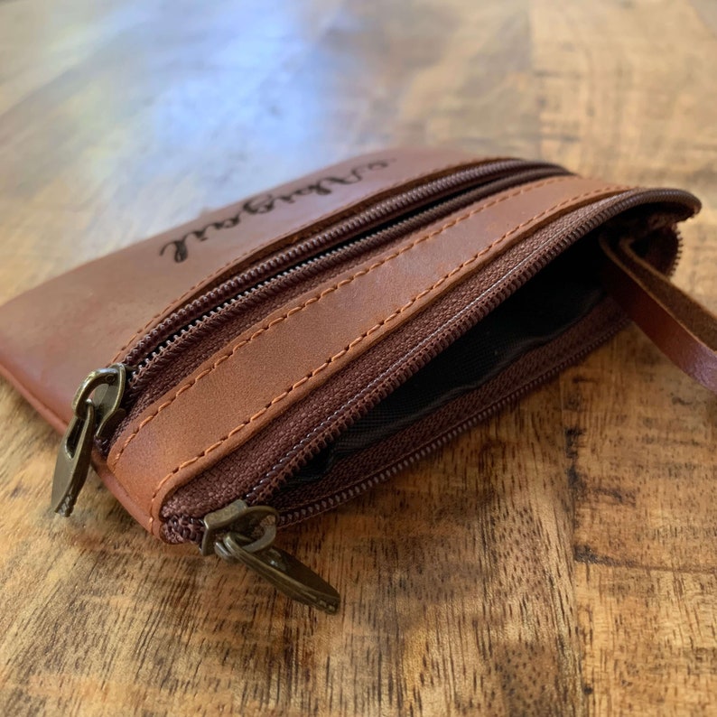 May include: A brown leather zippered pouch with a personalized inscription that reads "Sarah Joy".