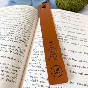 Peut inclure: Un marque-page en cuir marron avec un c&oelig;ur et le texte "You are my happily ever after" et les initiales "S+H" avec la date "08.18.18".
