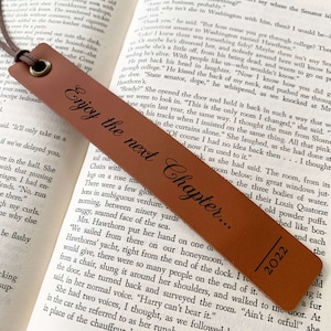 May include: A brown leather bookmark with the text "Enjoy the next Chapter..." and the year 2022 printed on it.