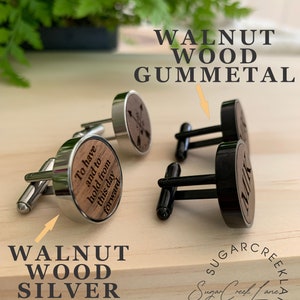 May include: Two pairs of cufflinks with walnut wood inlays. One pair has a silver finish and the other has a gunmetal finish. The silver pair has the text "To have and to hold from this day forward" engraved on the wood inlay. The gunmetal pair has the text "Milk" engraved on the wood inlay.