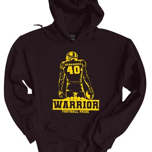 May include: Black hooded sweatshirt with a yellow silhouette of a football player wearing jersey number 40 with the name "Hernandez" on the back. The text "WARRIOR FOOTBALL PRIDE" is printed below the player.