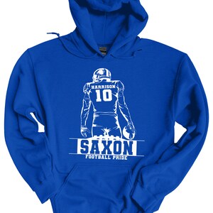 May include: Royal blue hooded sweatshirt with a white silhouette of a football player wearing jersey number 10 with the name "HARRISON" above the number. The text "SAXON FOOTBALL PRIDE" is below the player.