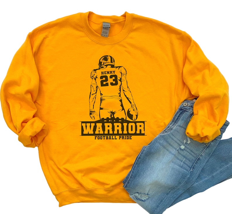 May include: Yellow sweatshirt with a black silhouette of a football player wearing the number 23 and the name "HENRY" above the number. The text "WARRIOR FOOTBALL PRIDE" is below the player.