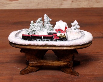 Encantadora mesa navideña en miniatura con tren para la casa de muñecas.