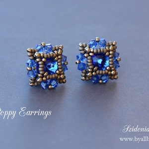 Op de afbeelding: Blauwe klaproos oorbellen met een vierkant ontwerp, bestaande uit blauwe en zilveren kralen.