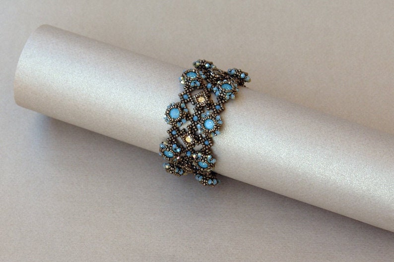 K&ouml;nnte beinhalten: Ein Armband mit Perlen in geometrischem Design mit blauen und goldenen Perlen.