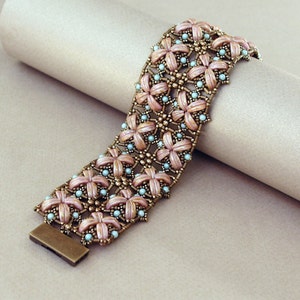 Pu&ograve; includere: Un braccialetto di perline rosa e blu con un design floreale. Il braccialetto &egrave; realizzato con piccole perline rotonde e ha una chiusura in metallo.