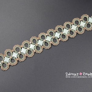 May include: A delicate bracelet made with small, light green and gold beads, featuring a repeating pattern of star-shaped beads. The bracelet is made with a woven technique, creating a lacy effect.
