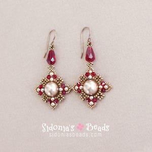May include: A pair of silver earrings with a square design. The earrings are made with red and white beads and feature a pearl in the center.