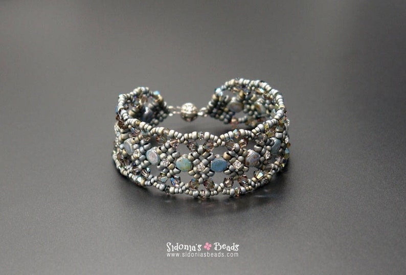 May include: A silver beaded bracelet with a woven design and iridescent blue and grey beads.