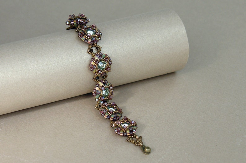 Pu&ograve; includere: Un braccialetto di perline con un design delicato che presenta piccole perline iridescenti in tonalit&agrave; di rosa, verde e oro. Il braccialetto &egrave; realizzato con una variet&agrave; di perline, tra cui perline a seme, perline bugle e perline sfaccettate.