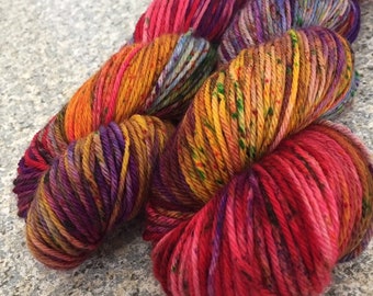 Könnte beinhalten: Nahaufnahme von bunten Garnknäueln. Das Garn weist eine Mischung aus leuchtenden Farben auf, darunter Rot, Orange, Gelb, Lila und Blau. Das Garn ist eng gewickelt und zeigt seine Textur und die komplizierten Farbvariationen im gesamten Knäuel.