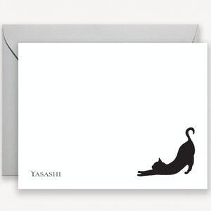 May include: A white card with a black silhouette of a cat stretching. The text "YASASHI" is printed in the bottom left corner.