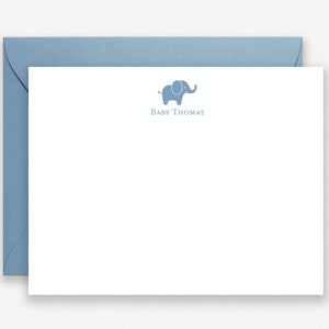 May include: A white card with a blue elephant illustration and the text "Baby Thomas". The card is on top of a blue envelope.