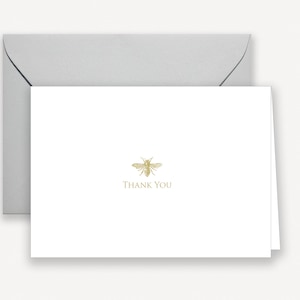 May include: A white thank you card with a gold bee illustration and the text "Thank You".
