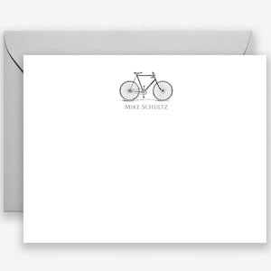 Puede incluir: Una tarjeta blanca con una ilustraci&oacute;n en blanco y negro de una bicicleta y el texto "Mike Schultz" impreso debajo de la imagen.