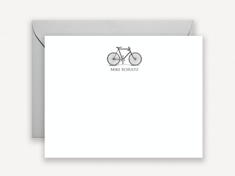 Puede incluir: Una tarjeta blanca con una ilustraci&oacute;n en blanco y negro de una bicicleta y el texto "Mike Schultz" impreso debajo de la imagen.