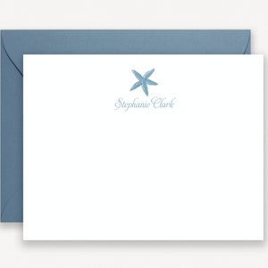 Könnte beinhalten: Eine weiße Briefkarte mit einem blauen Seestern-Design und dem Namen "Stephanie Clark" in blauer Schrift.