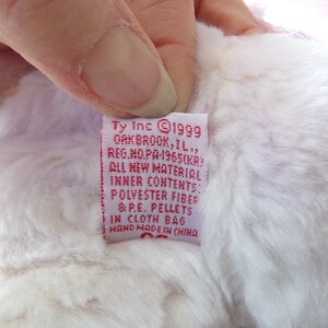 Peut inclure: &Eacute;tiquette en tissu rose et blanc avec le texte "Ty Inc 1999 Oakbrook, IL, Reg. No. PA 1965(KR) All New Material Inner Contents Polyester Fiber & P.E. Pellets in Cloth Bag Hand Made in China"
