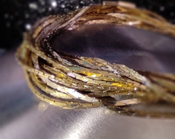 61 cm halsband med flera kedjor i två färger. Vridet, fyrkantigt halsband med tunt kedjeband, en länk saknas.