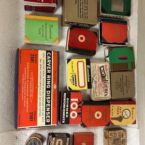 May include: A collection of vintage office and stationery supplies in small cardboard boxes, including Dennison's gummed cloth mending tape, Carver Ring Dispenser, Ace gummed reinforcements, Mint Jujubes, and various key tags and paper clips.