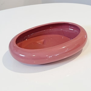 May include: A dusty rose oval ceramic planter. The planter has a smooth, glossy finish.