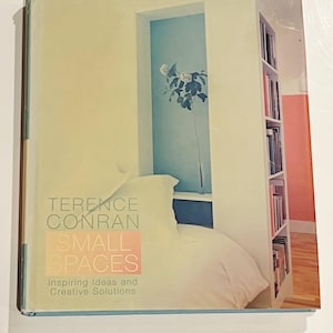 May include: A book cover for "Small Spaces" by Terence Conran. The cover features a minimalist interior design scene with a bed, a window, and a bookshelf. The book's title is in large, bold letters, with the subtitle "Inspiring Ideas and Creative Solutions".