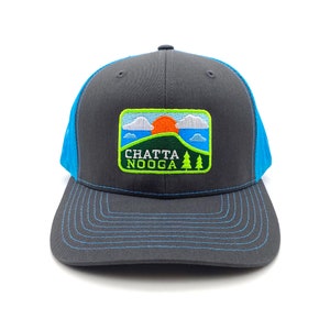 May include: A black and blue trucker hat with a green, orange, and blue embroidered patch that says "Chattanooga" on it.