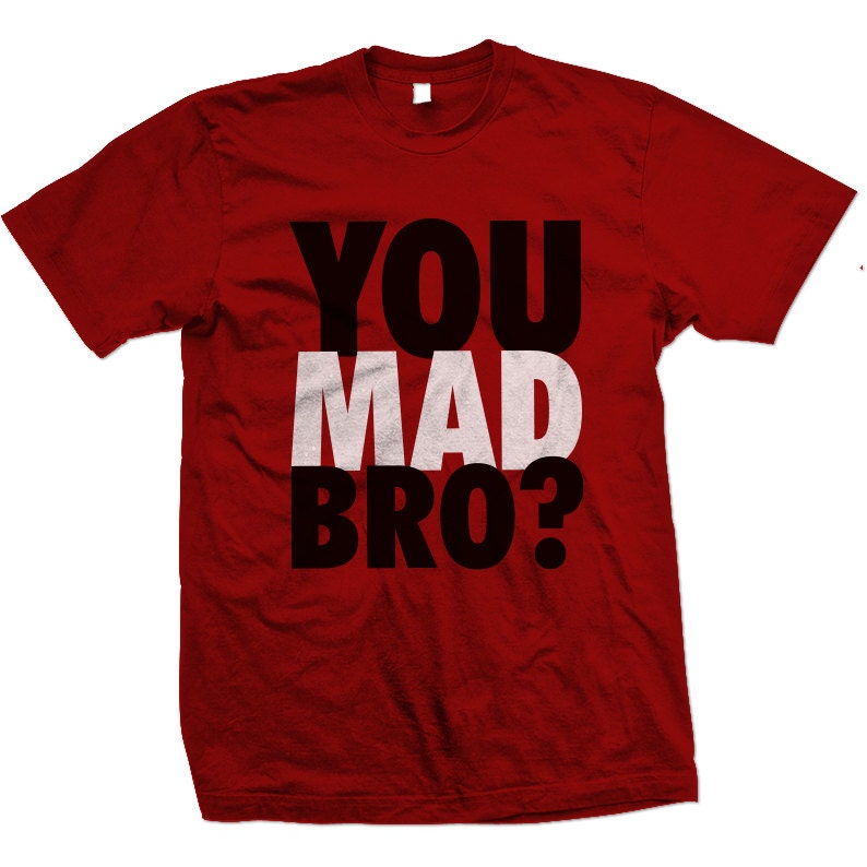 Puede incluir: Camiseta roja con el texto "YOU MAD BRO?" en letras negras y blancas.