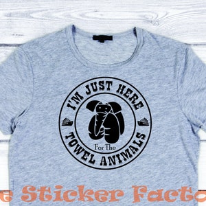 May include: A gray t-shirt with a black circle graphic that says "I'm Just Here For The Towel Animals".