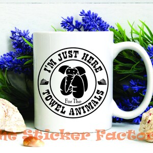 May include: White ceramic mug with a black and white graphic that says "I'm Just Here For The Towel Animals". The graphic is a circle with a cartoon animal inside.