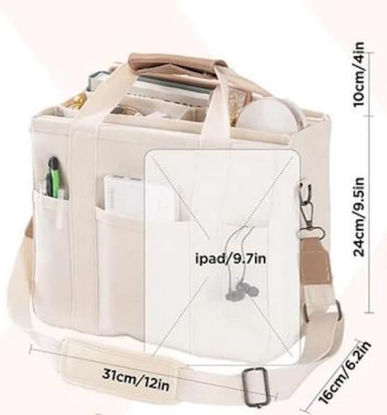 May include: Beige canvas tote bag with multiple compartments and a shoulder strap. The bag measures 12 inches wide, 9.5 inches high, and 6.2 inches deep. It has a top handle and a front pocket designed to hold an iPad.