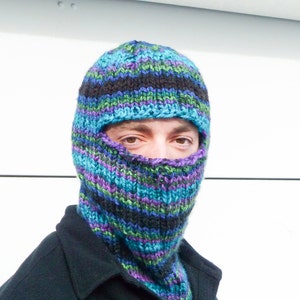 May include: A blue, green, and purple striped knitted balaclava with a hole for the eyes.