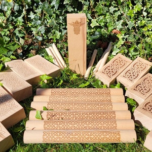 May include: A wooden Celtic knot game set with 6 wooden blocks and 6 wooden sticks. The blocks and sticks are decorated with intricate Celtic knot designs.