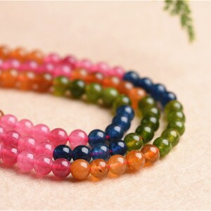May include: A multi-coloured beaded necklace with orange, pink, green and blue beads.