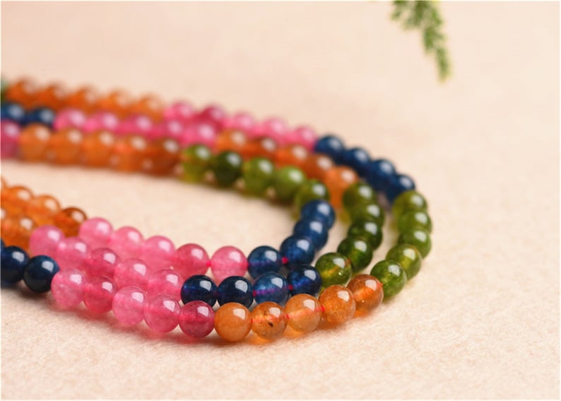 May include: A multi-coloured beaded necklace with orange, pink, green and blue beads.